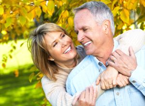 a couple smiles after discovering dental implants were the best tooth replacement options for them